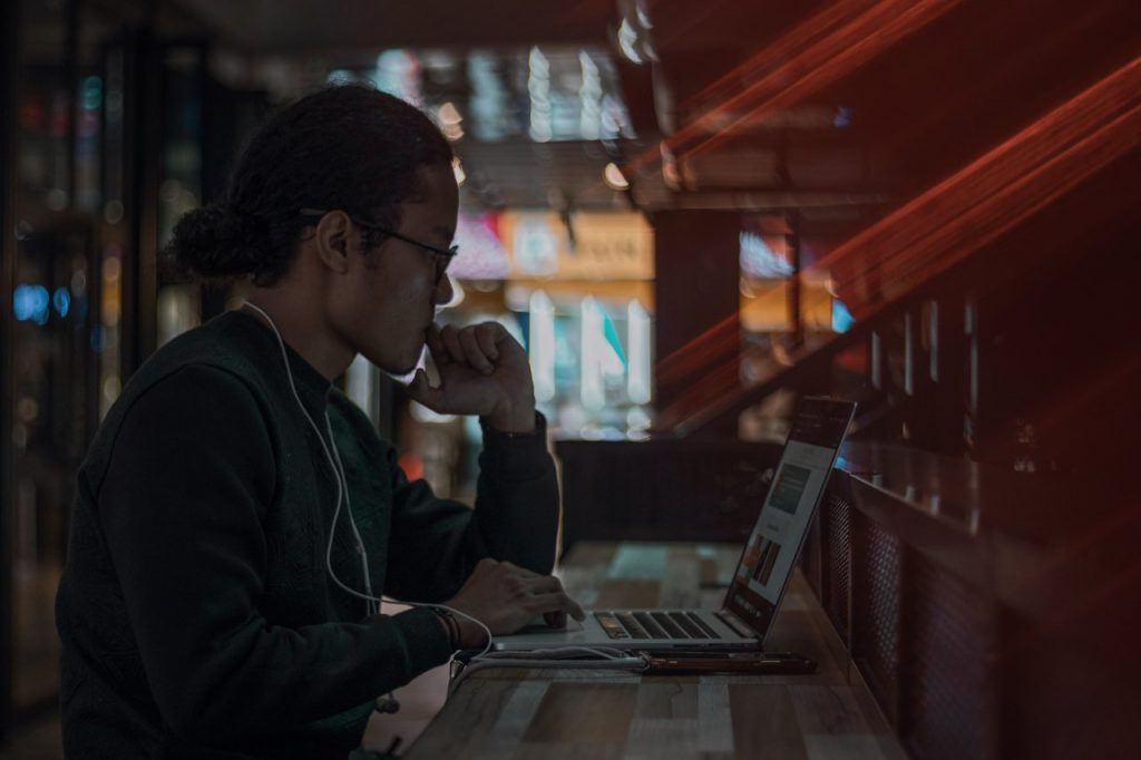 homem em frente a laptop se perguntando como melhorar o desempenho do notebook