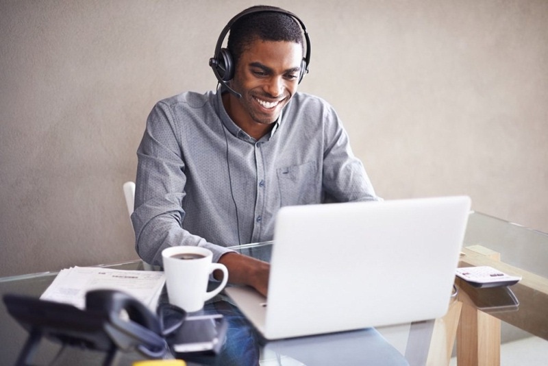 homem utilizando headset redragon enquanto usa o notebook