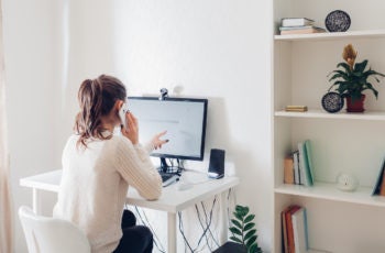 mulher em frente a um computador com uma webcam