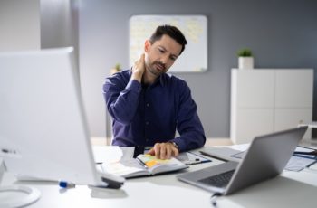 homem sem ergonomia no home office e com dores no pescoço