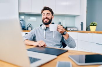 homem jovem tomando uma xícara de cafe no home office