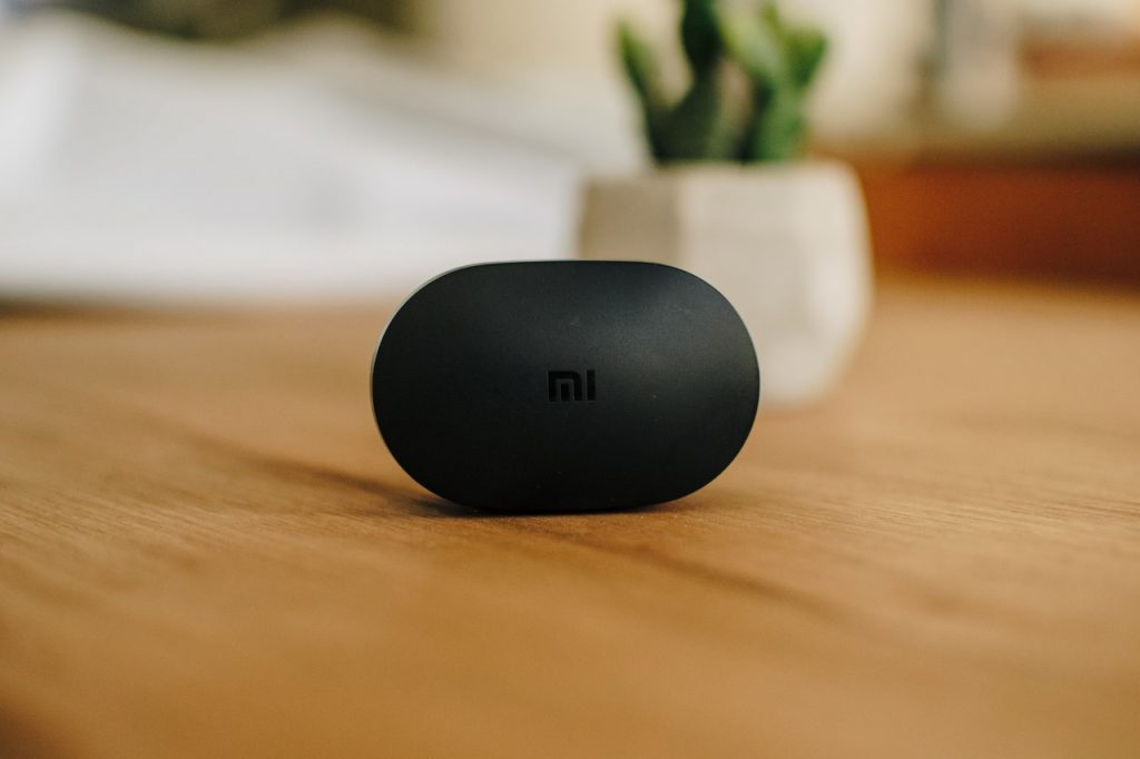 Fone da Xiaomi original sobre uma mesa de madeira com fundo desfocado