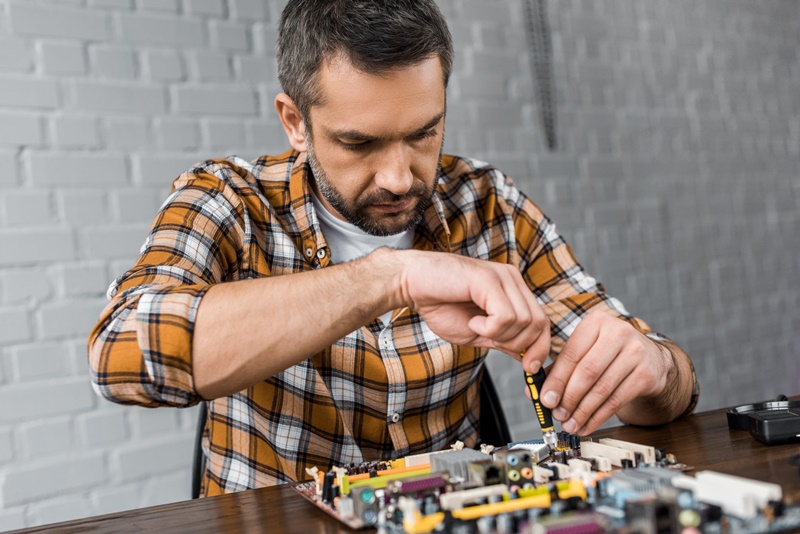 homem utilizando ferramentas em conserto de computador