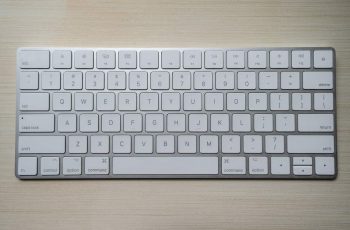 teclado apple branco sobre fundo de madeira
