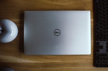 Notebook Dell com tela fechada ao lado de periféricos