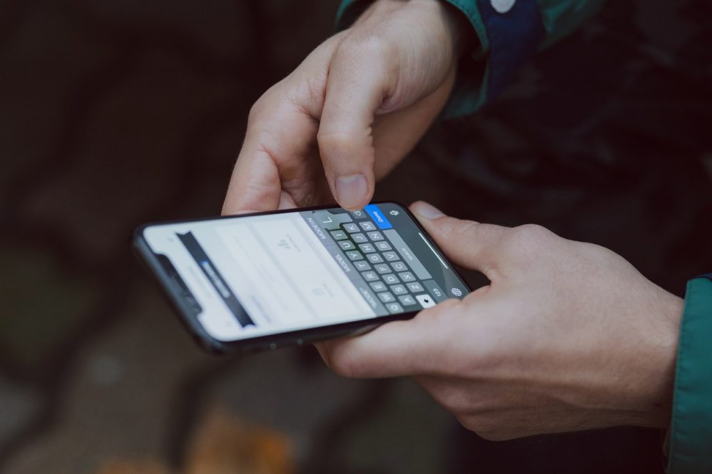 Pessoa digitando em um teclado de celular sem vibração