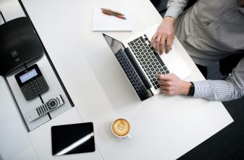 Homem utilizando touchpad de notebook sobre uma mesa