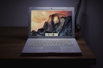 Notebook Mac com tela de fundo personalizada sobre mesa