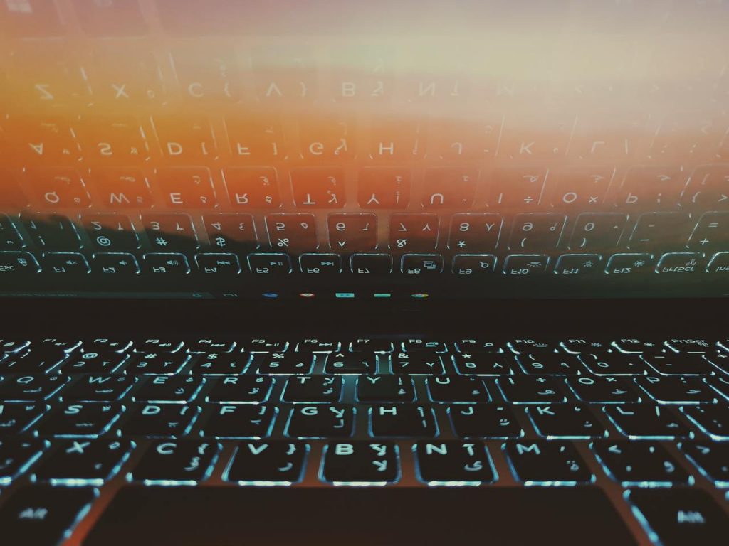 notebook com teclado iluminado refletindo em tela
