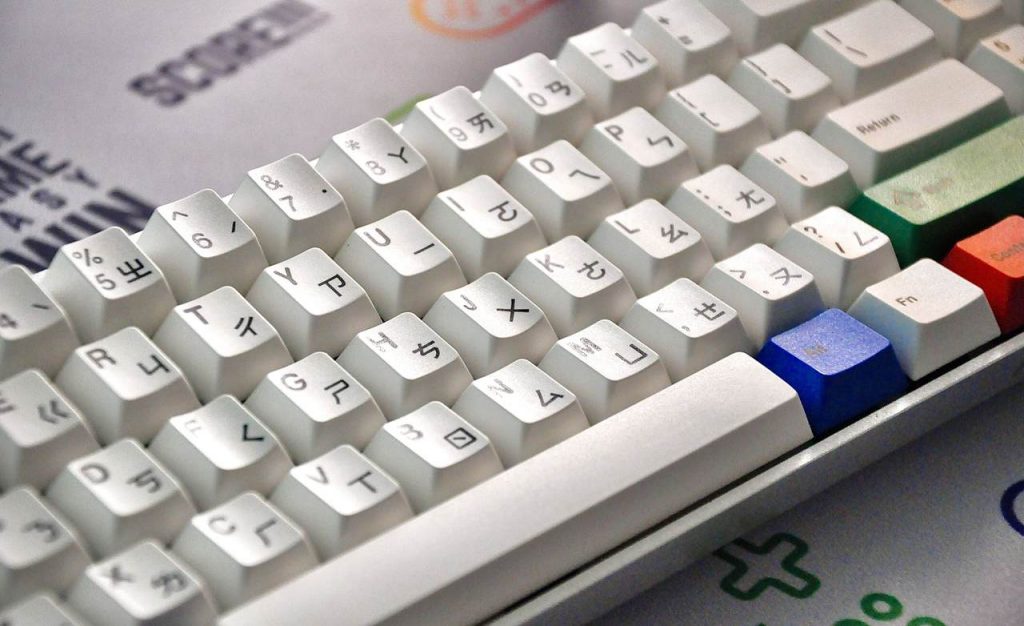 teclado branco gamer com algumas teclas coloridas