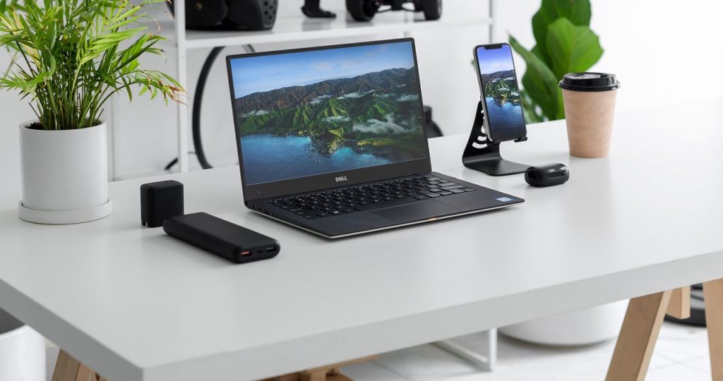 Notebook Dell Inspiron 14R sobre uma mesa branca com periféricos e plantas