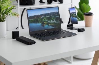 Notebook Dell Inspiron 14R sobre uma mesa branca com periféricos e plantas