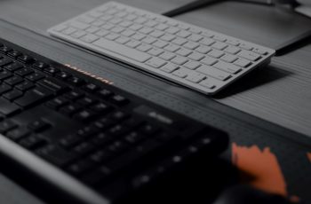 Dois tipos de teclado diferentes sobre uma mesa cinza