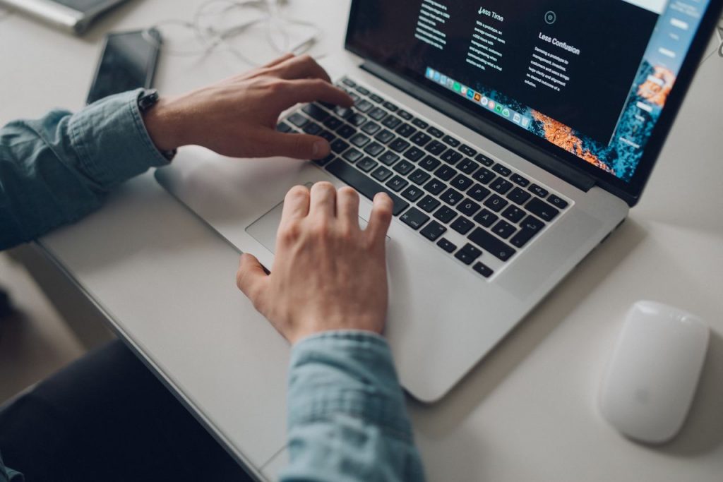 Homem com sua mão sobre um teclado tirando um print no notebook