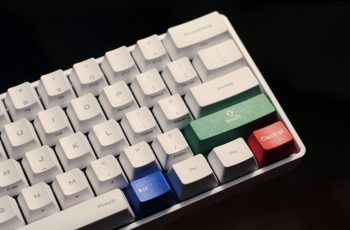 Teclado branco gamer com peças coloridas sobre fundo preto