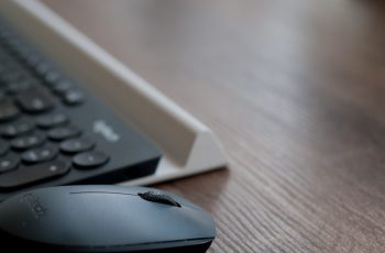 Teclado e mouse logitech em mesa de madeira