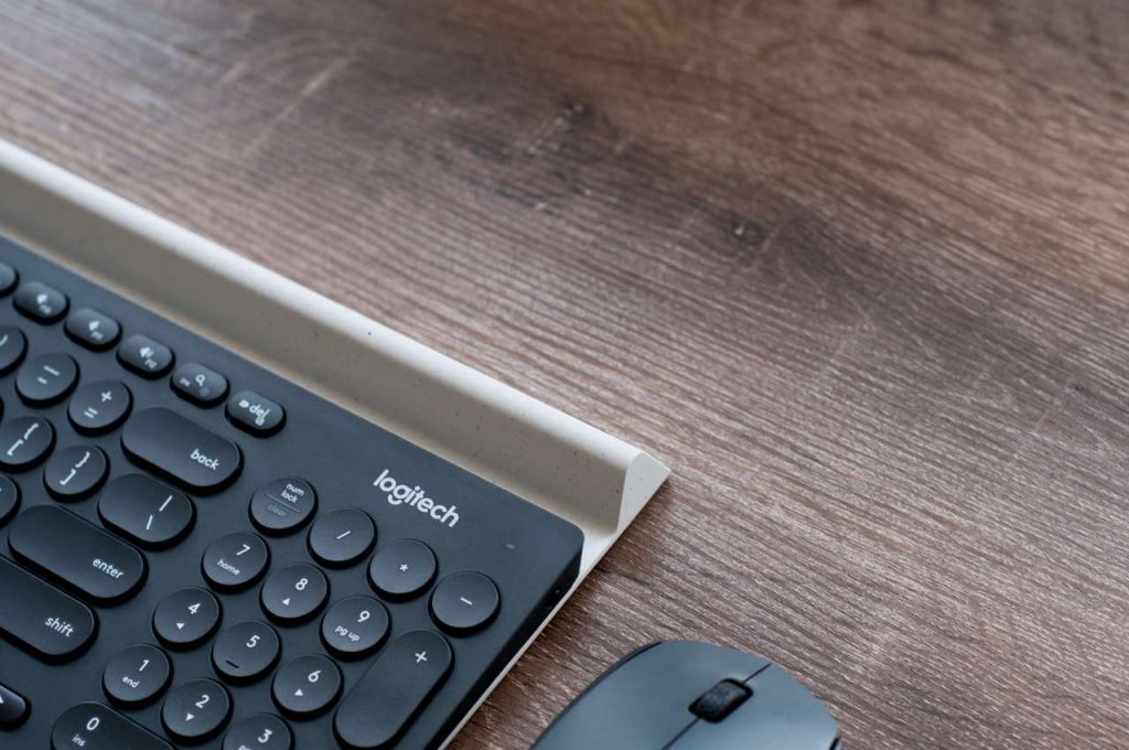 Mouse e teclado bluetooth logitech em mesa de madeira