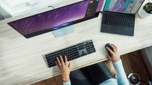 Pessoa utilizando notebook como monitor conectado à desktop