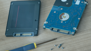 Dois SSDs em uma mesa, com uma chave e alguns parafusos