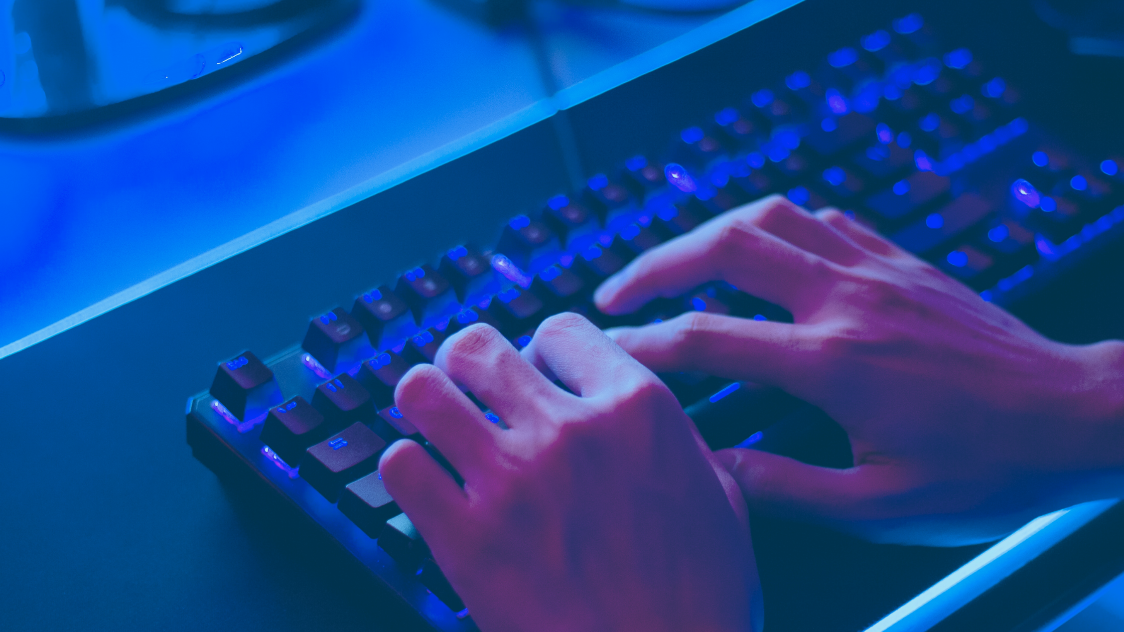 Teclado gamer azul com mão digitando