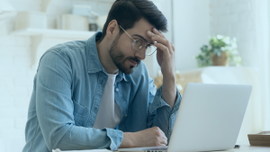 Homem preocupado olhando para seu notebook
