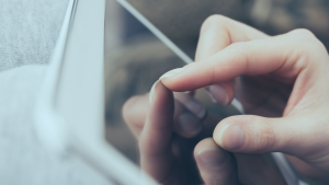 Dedos fazendo o movimento de zoom em uma tela de pc