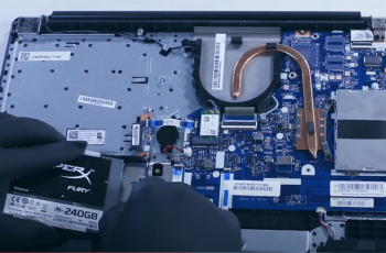 Homem com luvas instalando SSD em notebook Lenovo