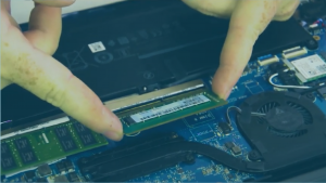 Mãos instalando a memória RAM em um notebook