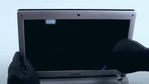 Pessoa realizando a troca de tela em um notebook Samsung