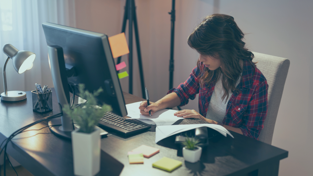 Mulher trabalhando em home office com computador na mesa