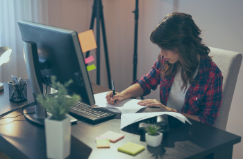 Mulher trabalhando em home office com computador na mesa