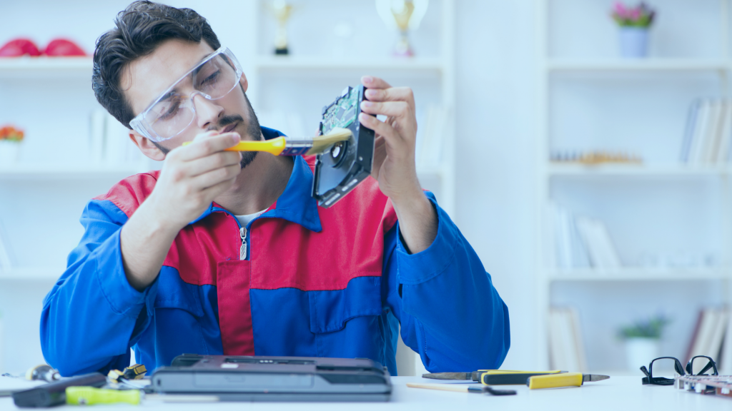 Técnico em informática consertando um notebook em sua assistência técnica