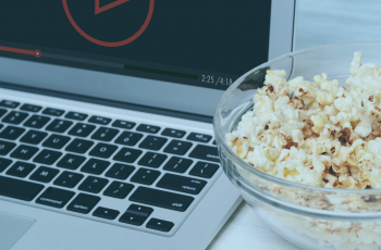 Notebook passando uma série na tela com um pote de pipoca ao lado