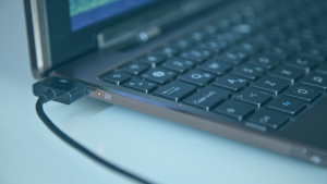 Lateral de um notebook conectado ao carregador