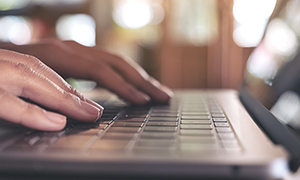mãos digitando confortavelmente em teclado de notebook